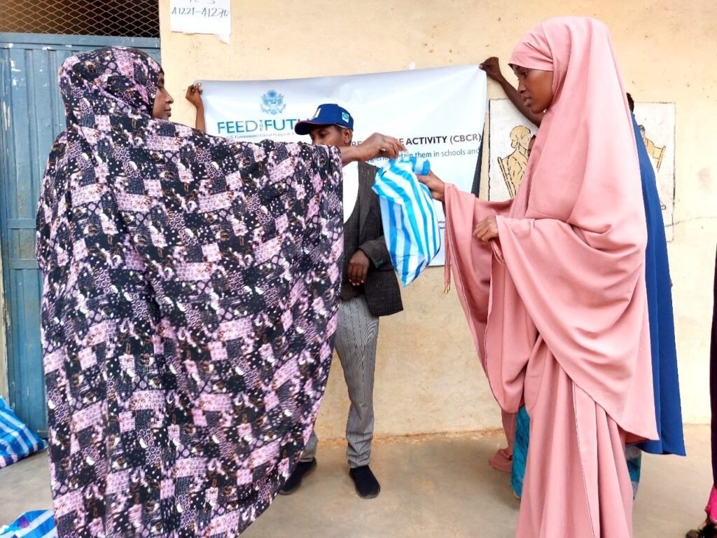 A woman receiving a dignity kit at a Cross-Border Community Resilience Activity distribution