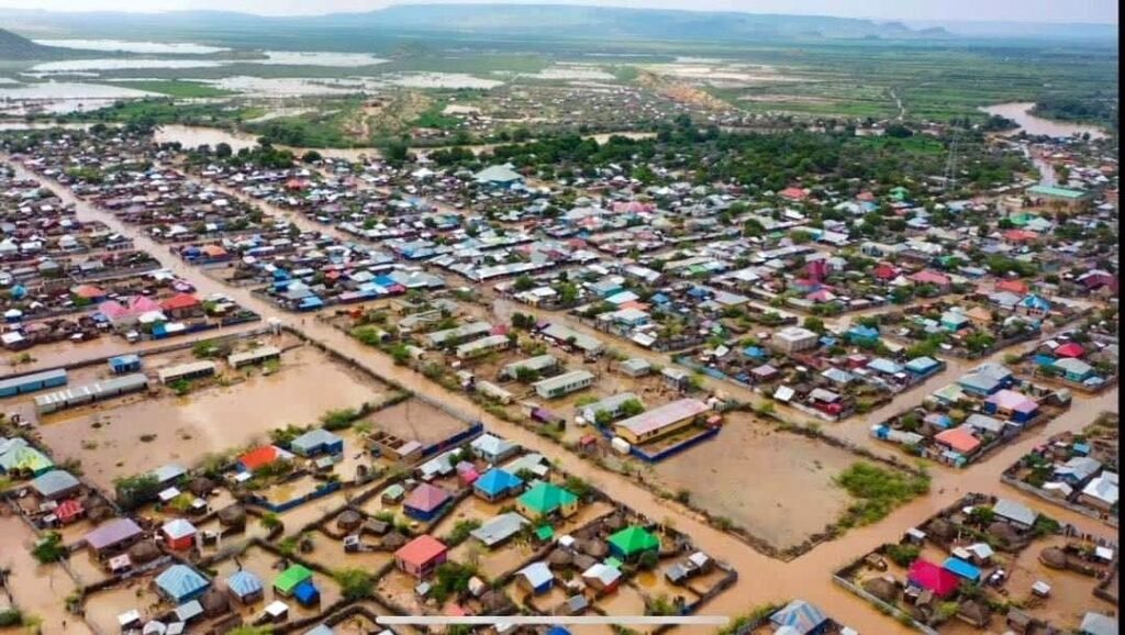 Aerial view of a flooded settlement in the Dollo area, homes and streets submerged after heavy rains, part of Wa-PYDO's drought and flood emergency response.