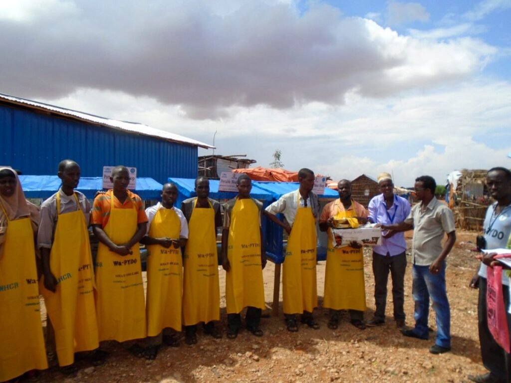Butchers in Wa-PYDO aprons at a meat marketing site in the Dollo Ado camps